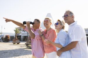 Four adults enjoying a sunny day at the beach, taking a selfie together.