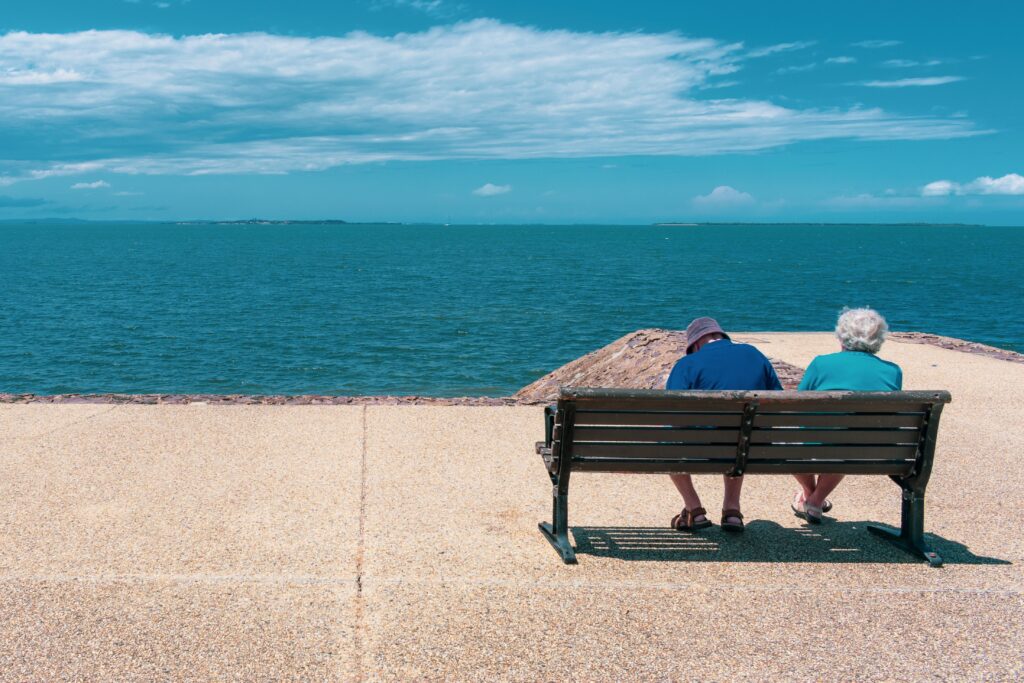 Older couple on bench overlooking ocean